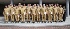 Pamiątkowe zdjęcie grupowe funkcjonariuszy PSP będących uczestnikami szkolenie z zakresu awaryjnego rozładunku cystern (23 osoby) w towarzystwie Zastępcy Komendanta Centralnej Szkoły PSP, kobiety, funkcjonariusza CS PSP oraz dwóch wykładowców