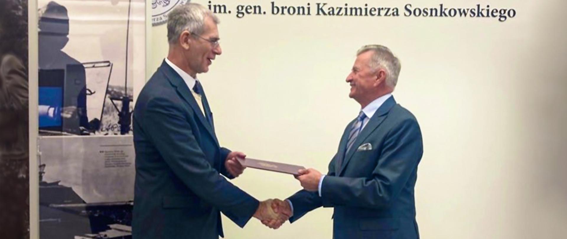 Na zdjęciu znajdują się dwie osoby - Podsekretarz Stanu w MON Pan Stanisław Wziątek oraz prof. dr hab. Grzegorz Motyka. Podsekretarz Stanu w MON Stanisław Wziątek wręcza powołanie nowemu dyrektorowi Wojskowego Biura Historycznego prof. dr. hab. Grzegorzowi Motyce. 