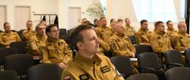 Kadra kierownicza Państwowej Straży Pożarnej województwa pomorskiego siedzi na krzesłach podczas odprawy.