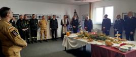 Na zdjęciu widoczni są: funkcjonariusze i pracownicy cywilni Komendy Powiatowej Państwowej Straży Pożarnej w Ostrowcu Świętokrzyski oraz Wiceprezes Zarządu Oddziału Wojewódzkiego Związku OSP RP, Wiceprezes Zarządu Oddziału Powiatowego Związku OSP RP, członkowie prezydium Zarządu Oddziału Powiatowego ZOSP RP oraz kapelan powiatowy strażaków podczas spotkania opłatkowego. 