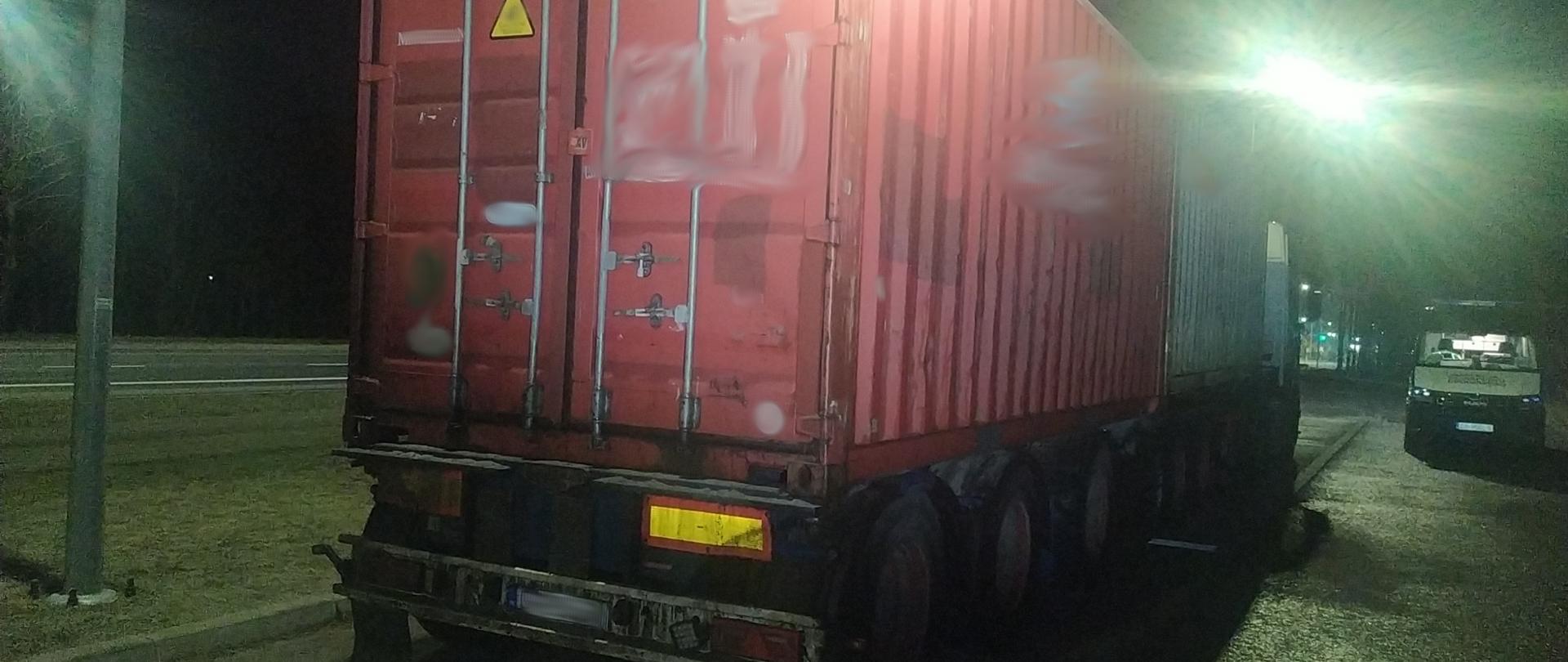 Dwa kontenery morskie na ciężarówce. Obok stoi radiowóz ITD.