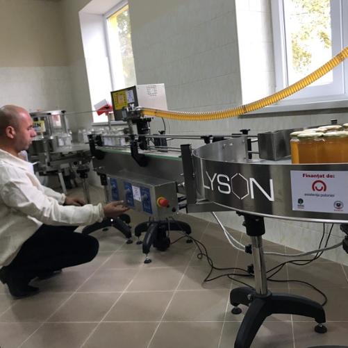 meżczyzna pracuje przy rozlewaniu miodu