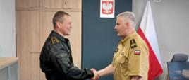 Komendant Powiatowy Państwowej Straży Pożarnej w Człuchowie st. bryg. Radosław Batruch stoi w gabinecie i wręcza akt mianowania na stanowisko dowódcy zmiany asp. Wojciechowi Kujszczyk.