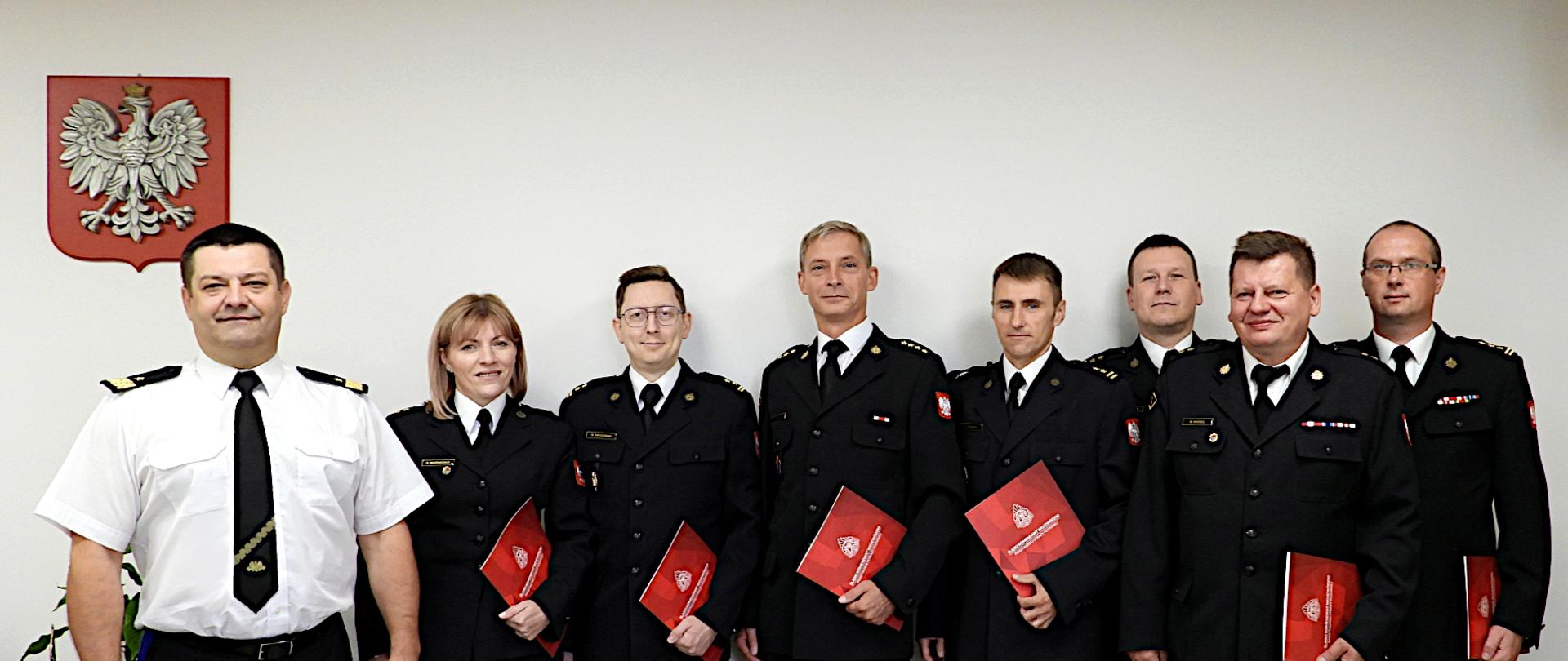 Na zdjęciu śląski komendant wojewódzki nadbryg. Jacek Kleszczewski wraz z członkami Komisji Dyscyplinarnej. Funkcjonariusze ubrani są w czarne mundury wyjściowe, w rekach trzymają podziekowania w czefrwonych teczkach.