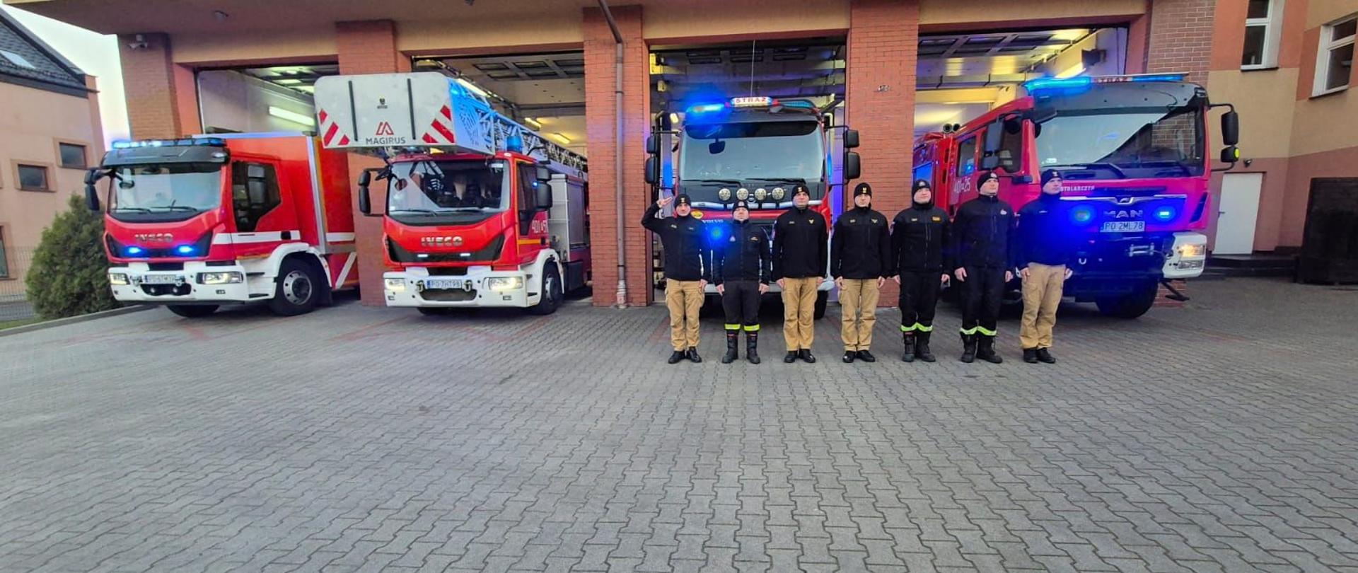 Zdjęcie przedstawia strażaków oddających hołd strażakowi, PSP, który zmarł w czasie służby.
W tle samochody strażackie oraz budynek Jednostki Ratowniczo - Gaśniczej.

