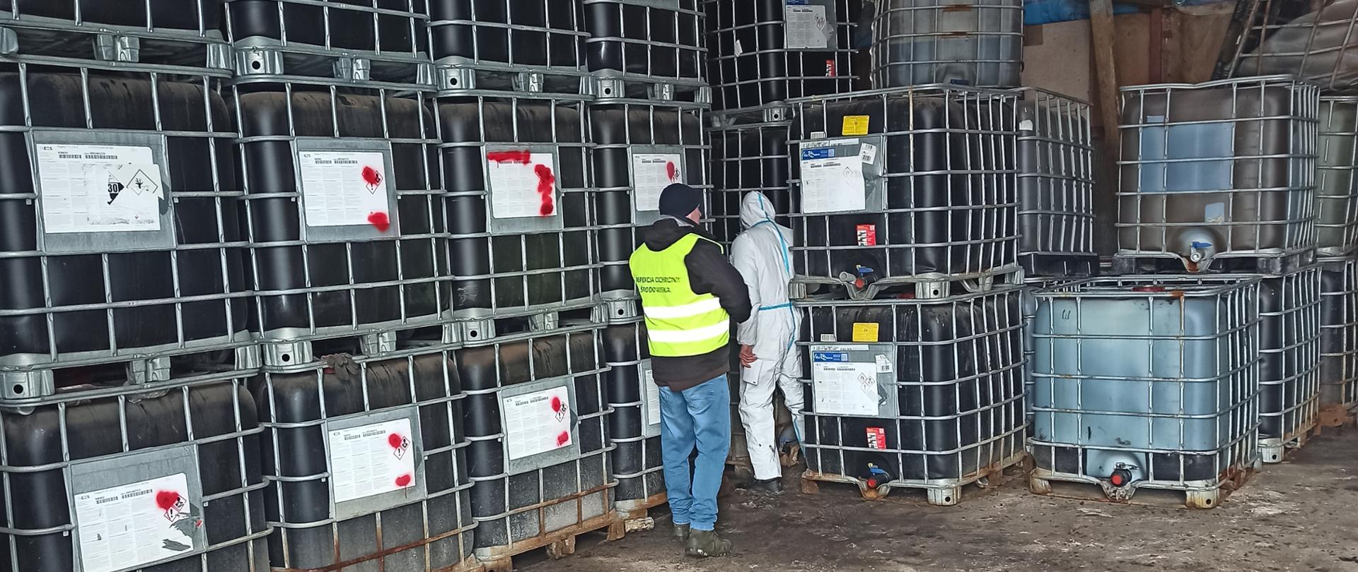 Hala magazynowa, w której stoją mauzery, a między nimi inspektor Inspekcji Ochrony Środowiska 