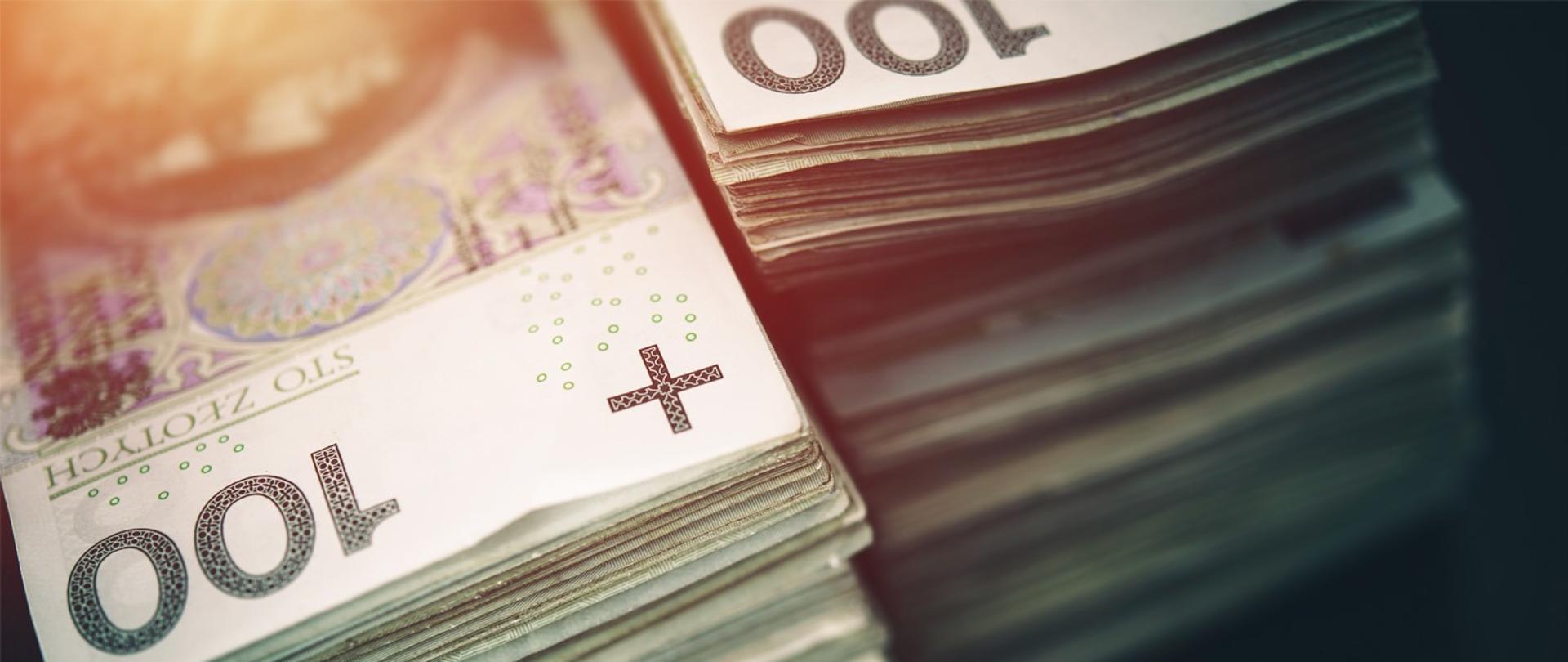 Na grafice widoczne banknoty 100 zł.