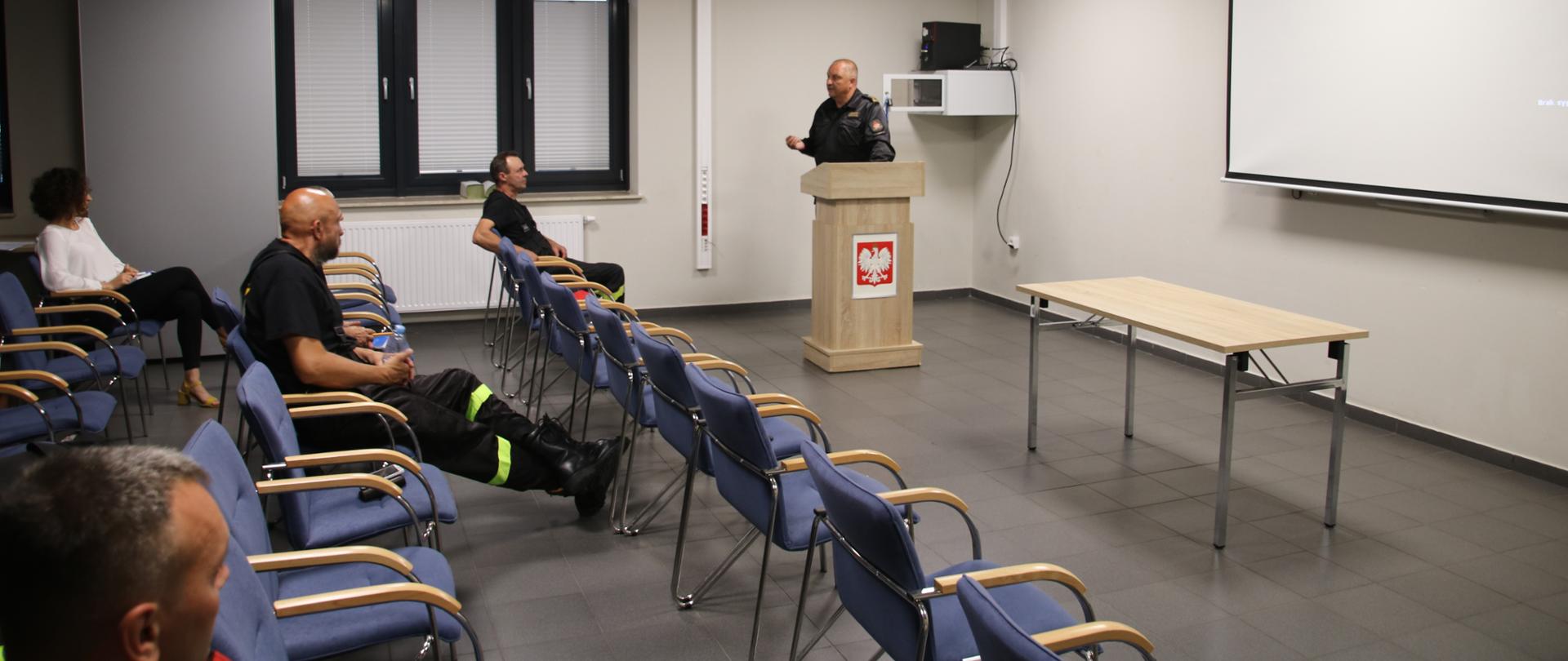 Zdjęcie przedstawia sale wykładową Komendy Powiatowej PSP w Żninie w której siedzą druhowie OSP podczas spotkania poświęconego akcji "Szczepimy się z OSP" 