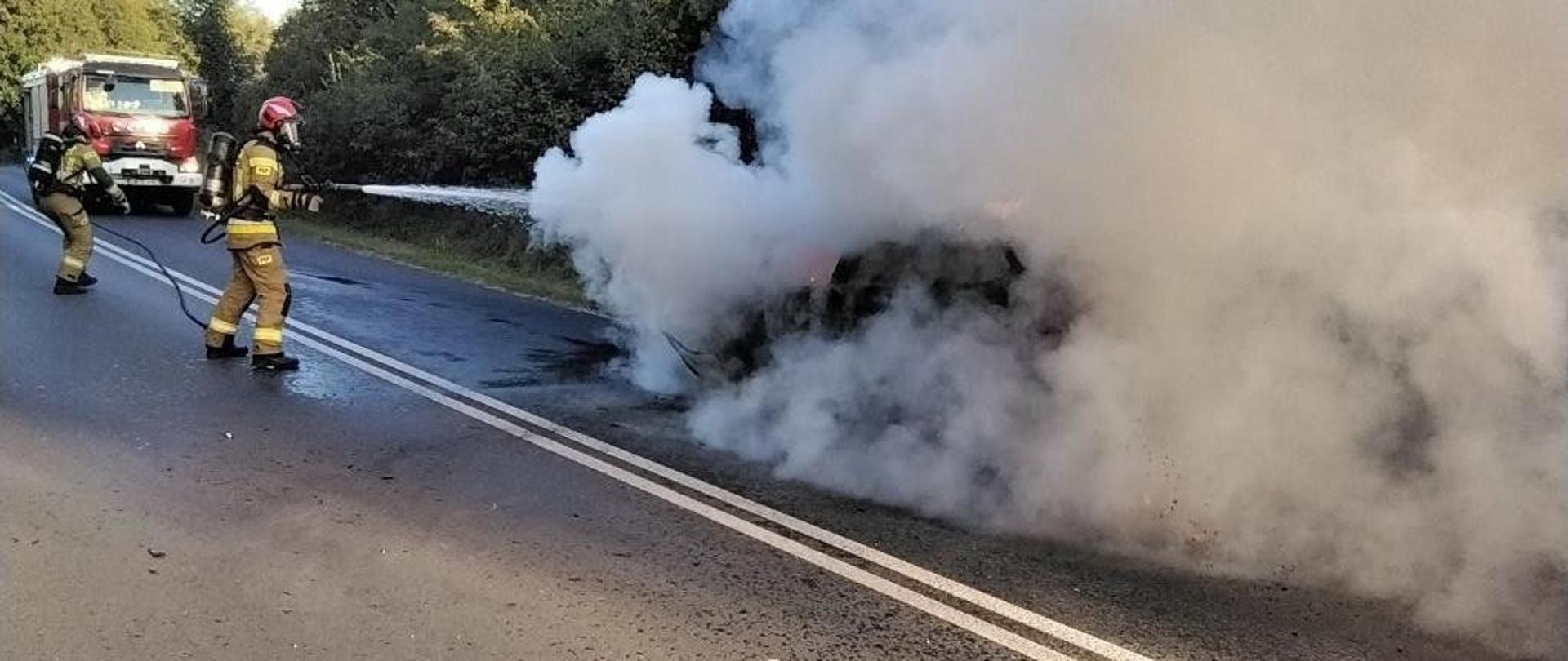 Strażak gasi palący się samochód