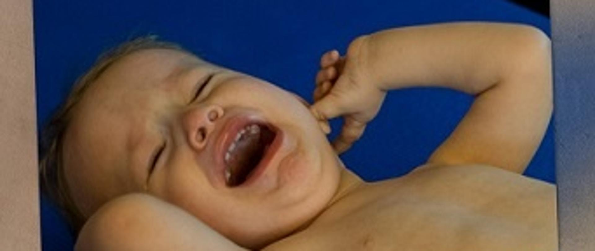 Zdjęcia przedstawia plączące małe dziecko.