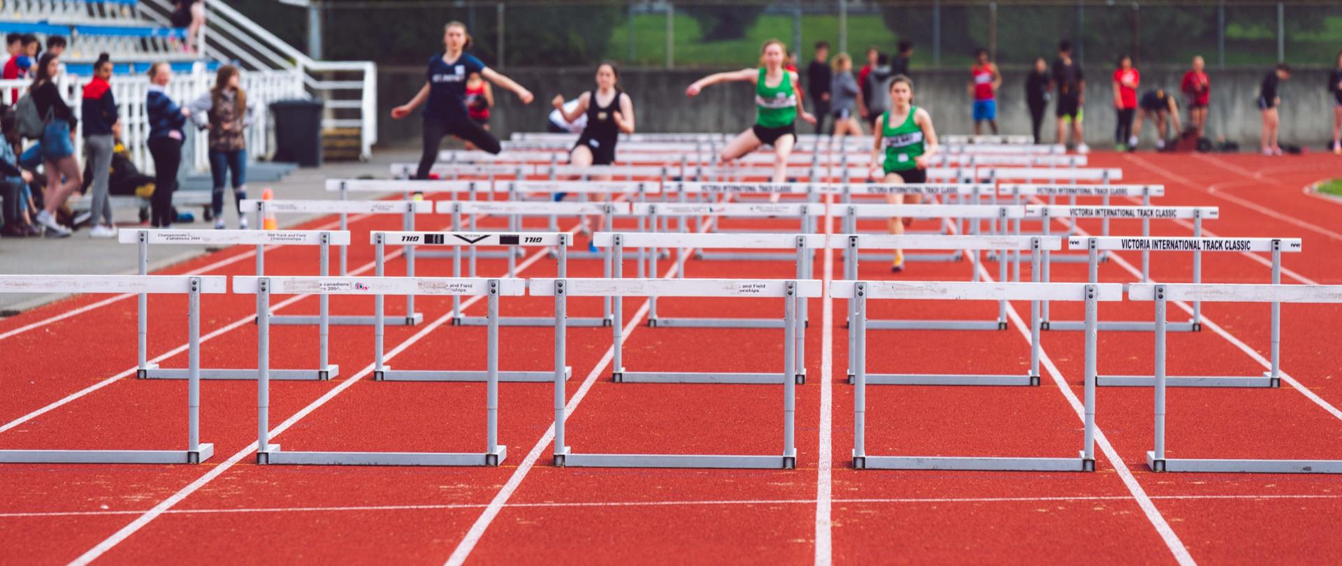 view of people running over hurdles on a treadmill
