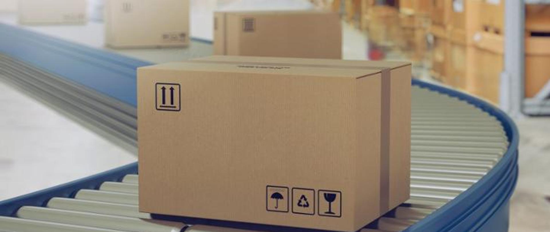 Zdjęcie przedstawia pudełko na taśmie w zakładzie pracy