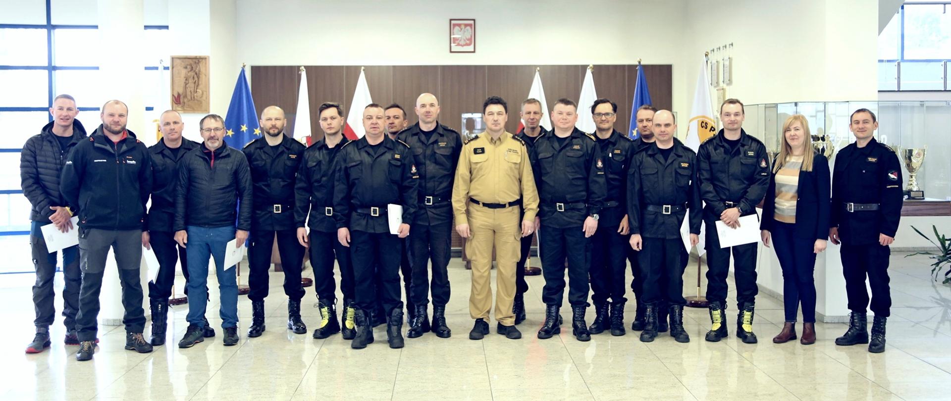 Grupowe zdjęcie uczestników warsztatów w towarzystwie Komendanta Centralnej Szkoły PSP, naczelnika oraz pracownicy wydziału szkoleń specjalistycznych i współpracy międzynarodowej oraz trójki instruktorów