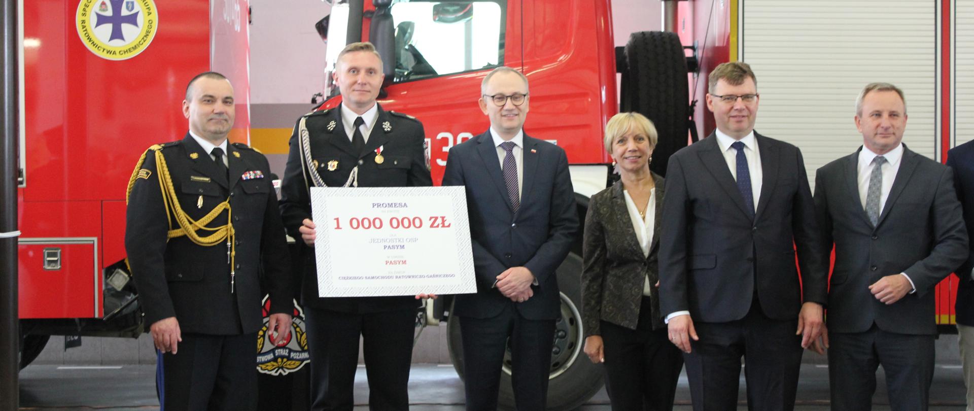 Zebrani goście stoją w szeregu, w tle samochód strażacki