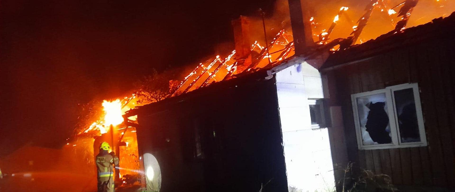 Strażak gasi pożar budynku