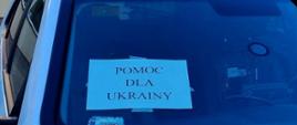 Samochód strażacki z napisem na szybie pomoc dla Ukrainy. 