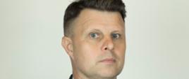 Zdjęcie przedstawia Komendanta Powiatowego PSP w Górze. Jest to portret w ciemnym mundurze strażackim na jasnoszarym tle. Na mundurze widoczne są oznaczenia stopnia, odznaczenia oraz tabliczka z nazwiskiem „K. Panocha”. Na lewym ramieniu znajduje się ozdobny złoty sznur.”