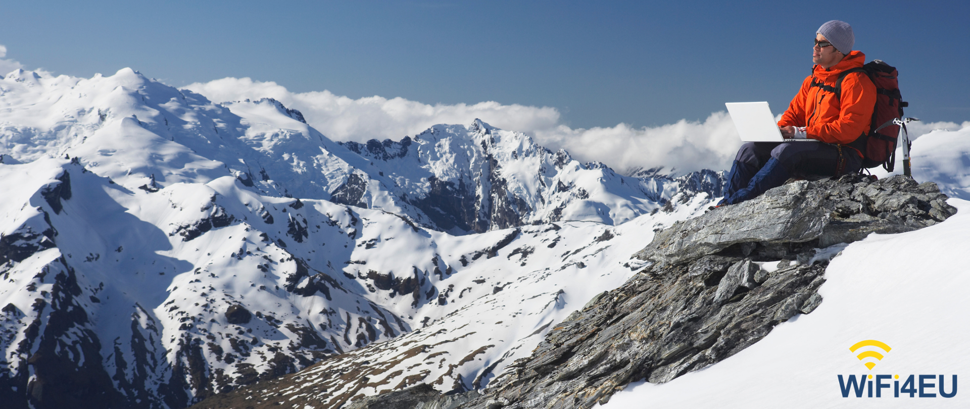 Człowiek z laptopem na szczycie góry