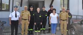 Na zdjęciu przed strażnicą OSP Kołacin na parkingu między samochodami stoją strażacy OSP Kołacin prezes oraz naczelnik tej jednostki, obok komendant gminny z gminy Dmosin, komendant powiatowy PSP w Brzezinach , zastępca komendanta wojewódzkiego PSP w Łodzi oraz Wójt Gminy Dmosin Danuta Supera