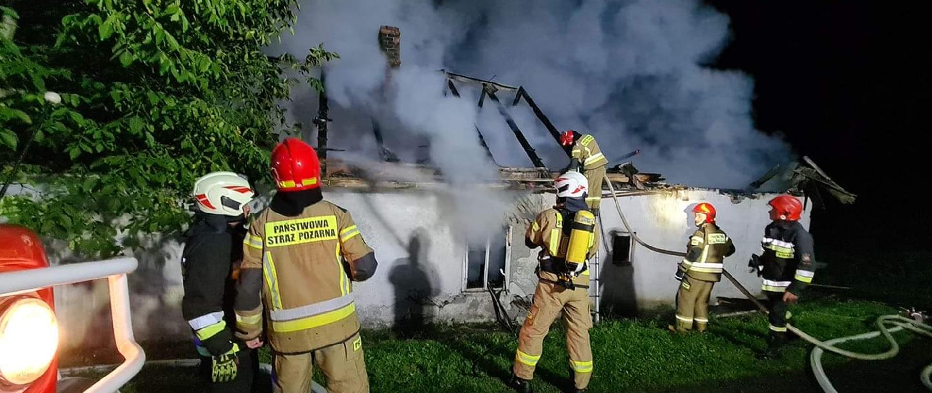Strażacy prowadza działania gaśnicze przy pożarze budynku w Brzeznej