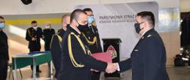 Warmińsko-Mazurski Komendant Wojewódzki w asyście Zastępcy Warmińsko-Mazurskiego Komendanta Wojewódzkiego i Komendanta Miejskiego PSP w Olsztynie wręcza decyzję mł. bryg. Łukaszowi Jasińskiemu