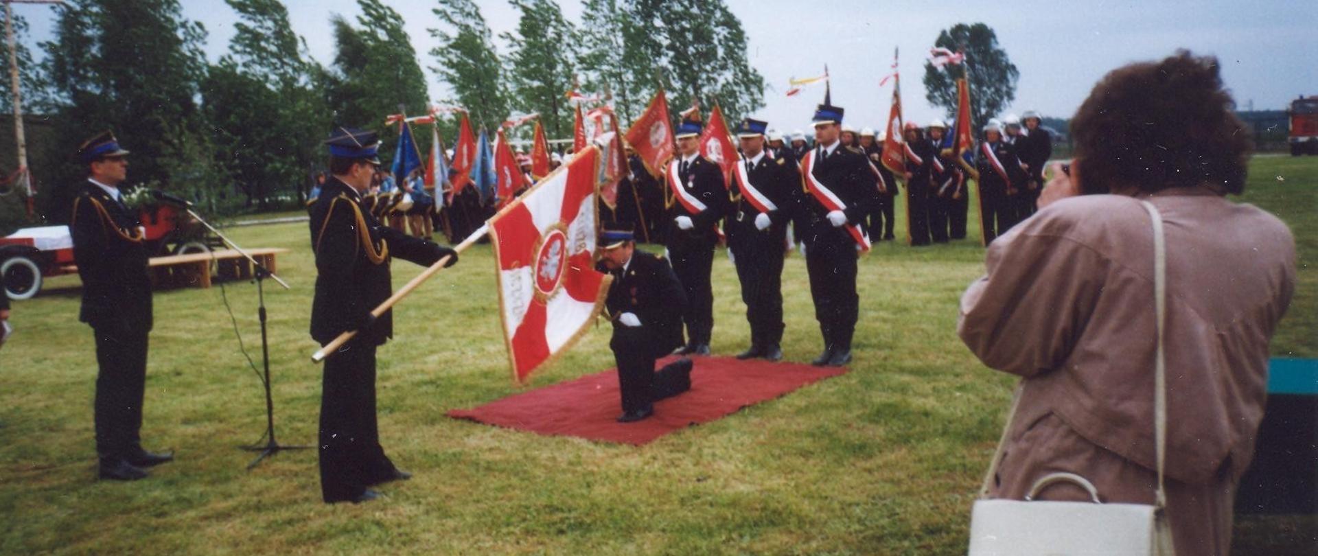 Zdjęcie przedstawia Uroczyste przekazanie sztandaru z okazji XXX-lecia zawodowego pożarnictwa dla JRG Koluszki. Sztandar całuje mł.bryg. Piotr Pakuła