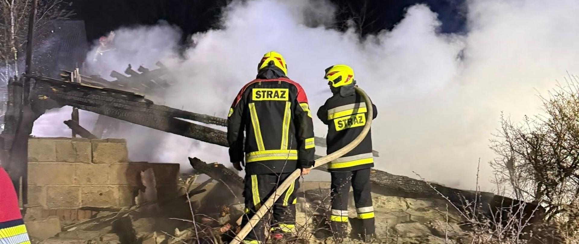 Strażacy gaszą pożar, jest noc