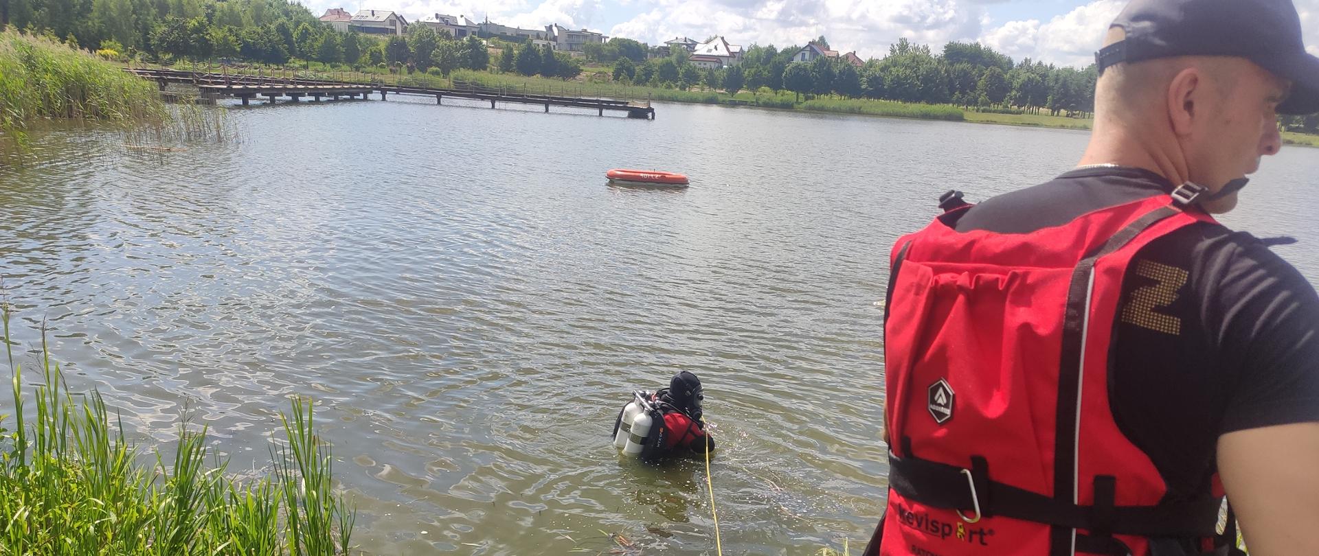 Płetwonurek udaje się na poszukiwanie osoby, która utonęła kilkadziesiąt minut wcześniej, w tle widoczna łódka, którą płynęli wędkarze