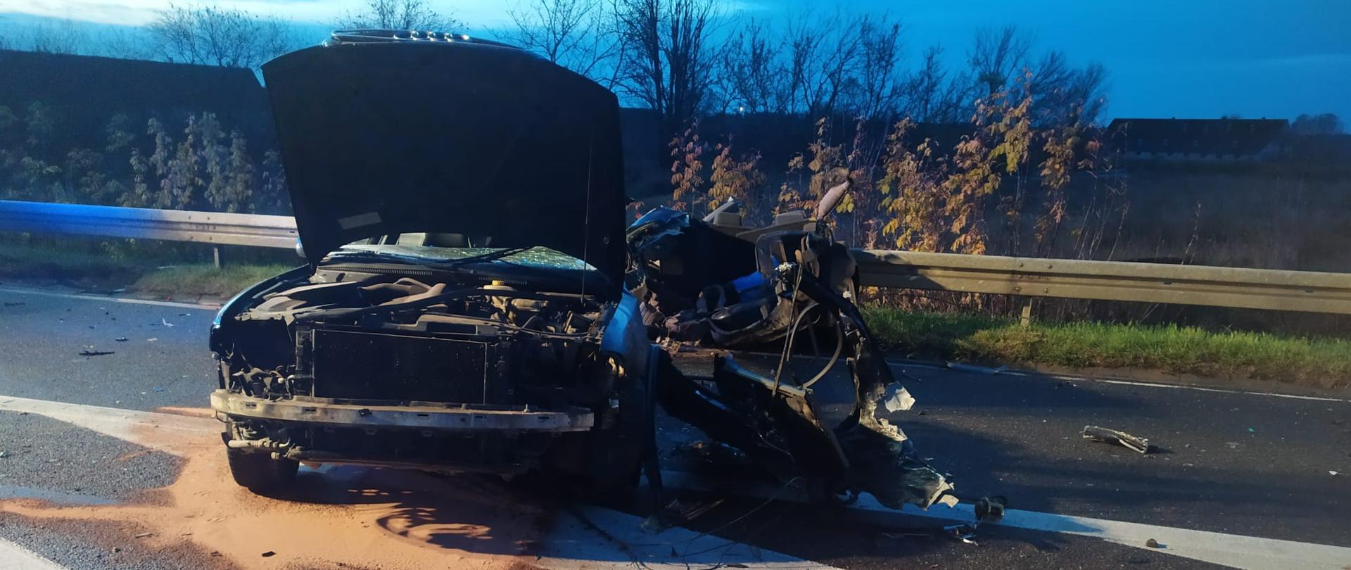 Uszkodzony przód pojazdu Audi A4 w wyniku zderzenia z innym pojazdem na drodze krajowej 61. Pod pojazdem sorbentem zostały zebrane plamy płynów eksploatacyjnych.