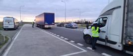 Umundurowani inspektorzy zachodniopomorskiej Inspekcji Transportu Drogowego stoją obok ciężarówki z naczepą oraz samochodu dostawczego i kontrolują trzeźwość kierowców. Kontrole są prowadzone w punkcie kontrolnym przy drodze ekspresowej S3 na MOP Kunowo.