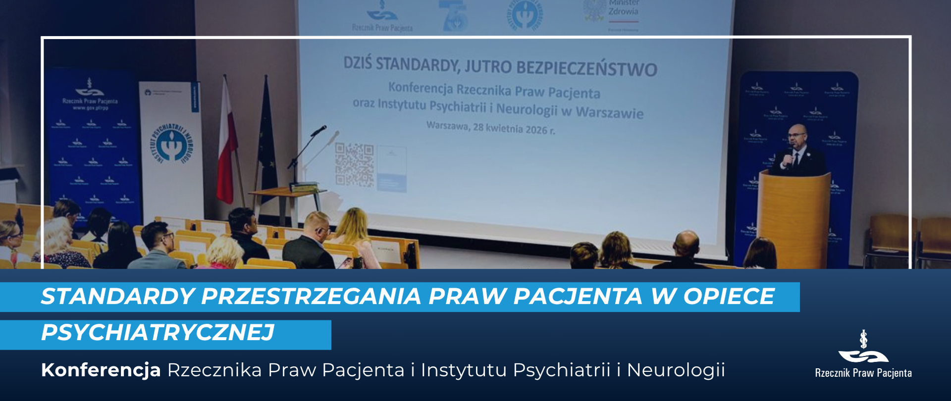 Bartłomiej Chmielowiec przy mównicy otwiera konferencję, na sali siedzą uczestnicy. 