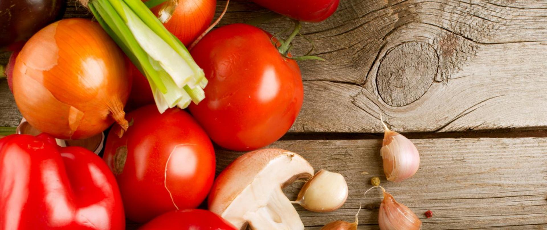 Na zdjęciu widoczne są warzywa. W tle widać drewniany blat.