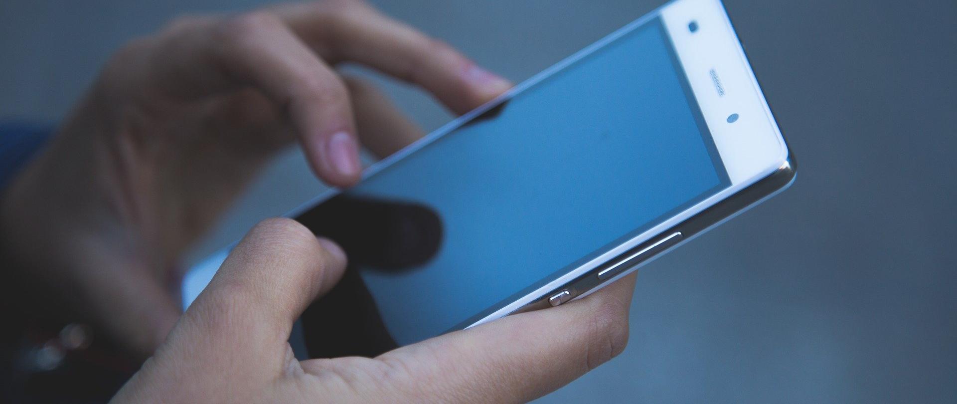 Ręce trzymające telefon komórkowy