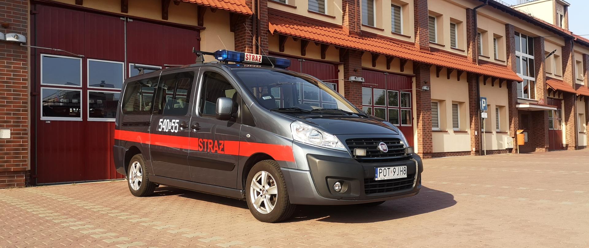 Na zdjęciu samochód specjalny typu Mikrobus na placu manewrowym przed garażami Jednostki Ratowniczo-Gaśniczej