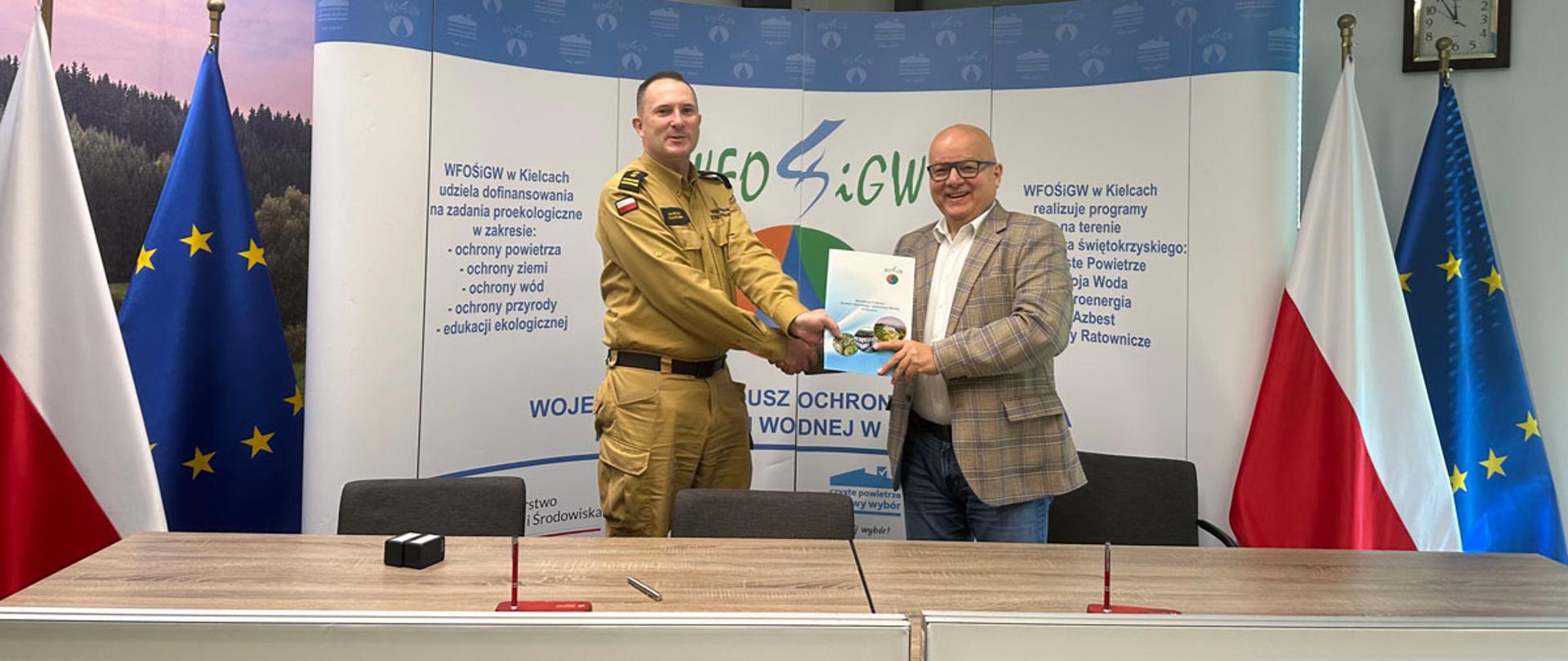 Na zdjeciu dówch meżczyzn podpisuje dokumenty