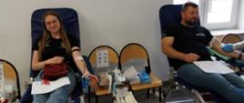 Na zajęciu widoczni mężczyzna w czarnej koszulce i jeansach i kobieta w czarnej koszulce i jeansach siedzący na fotelach na sali oddający krew podczas akcji zbiórki krwi zorganizowanej przez Klub Honorowych Dawców Krwi Polskiego Czerwonego Krzyża przy Komendzie Powiatowej Państwowej Straży Pożarnej w Gorlicach 