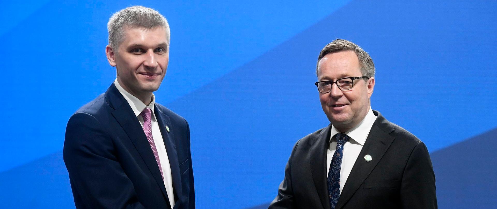 Uśmiechnięty wiceminister finansów Piotr Nowak i fińskim minister finansów Mika Lintila