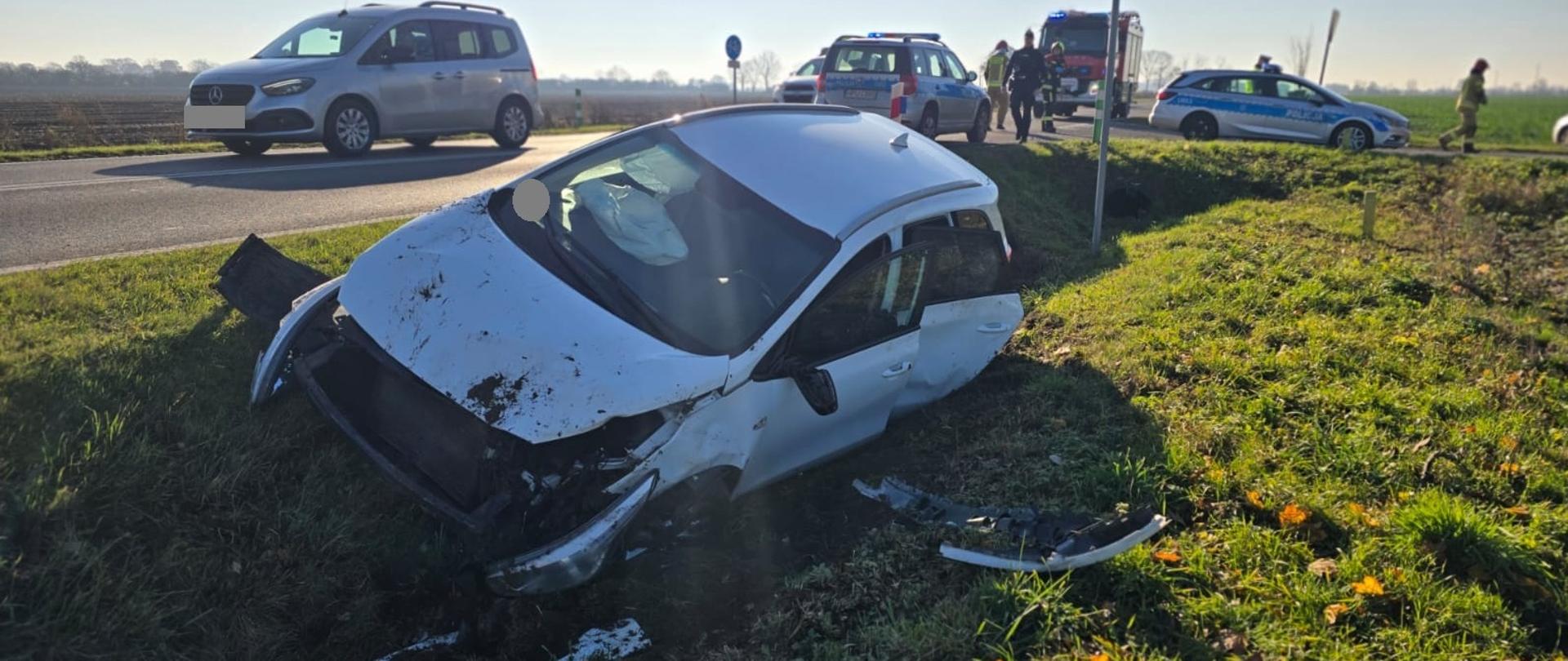 Samochód osobowy w rowie, za nim pojazdy policji