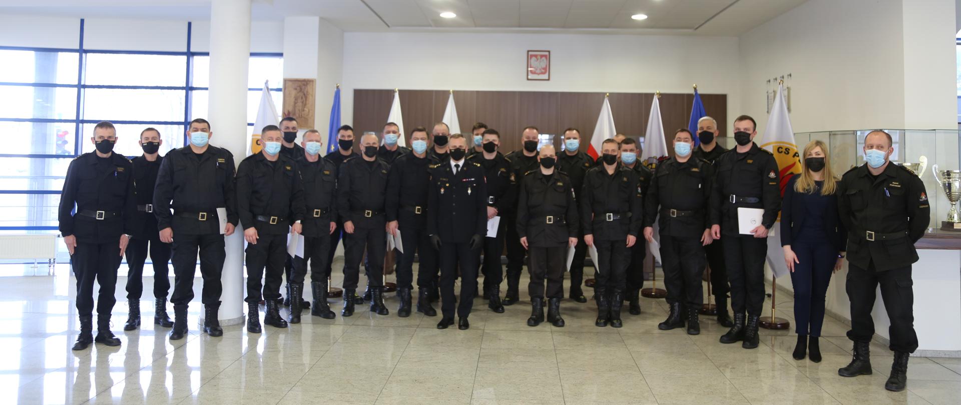 Grupowe zdjęcie uczestników szkolenia w towarzystwie Zastępcy Komendanta Centralnej Szkoły PSP oraz pracowników Szkoły sprawującymi nadzór nad szkoleniem