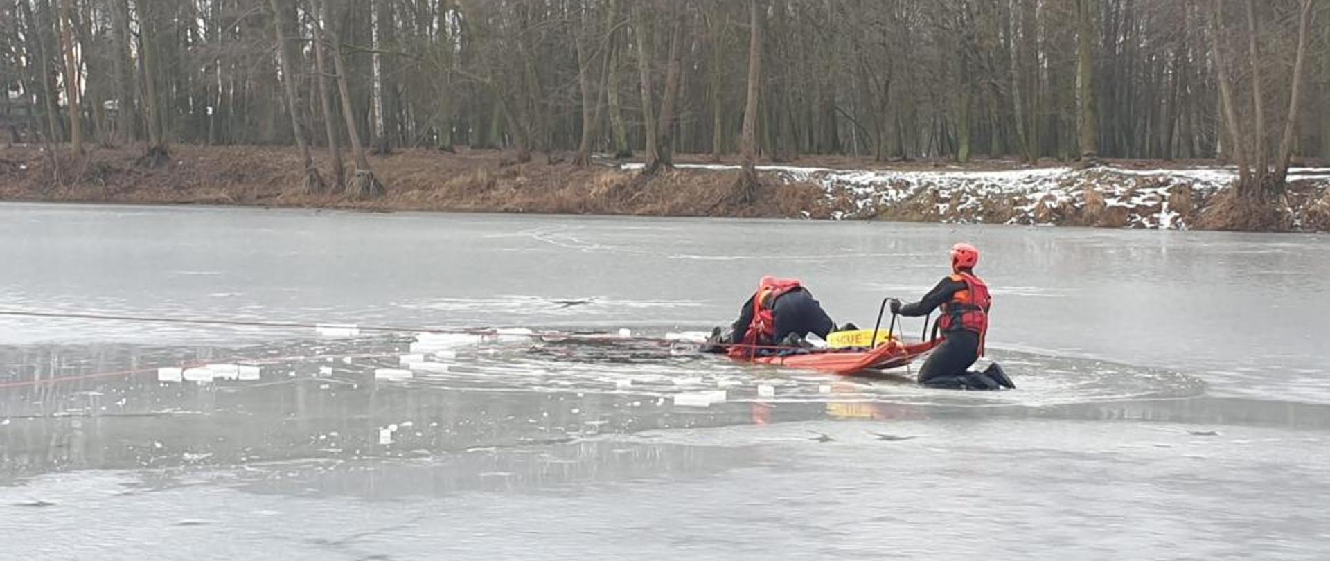 Na zdjęciu ratownicy PSP zabezpieczeni na lodzie podczas ćwiczeń z deską lodową