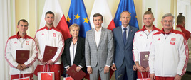 Minister Witold Bańka oraz Wiceminister Jan Widera z zawodnikami oraz trenerami Eulalią Rolińską i Andrzejem Kijowskim przy flagach