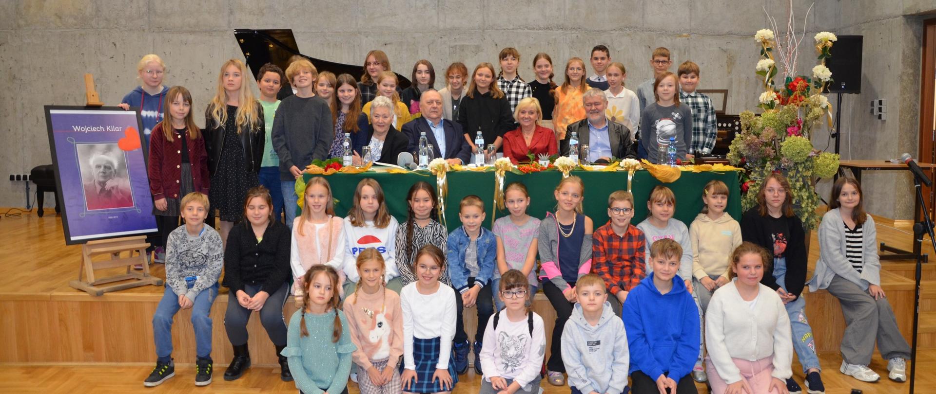 Grupa uczniów wraz z gośćmi na sali koncertowej