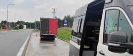 Kontrola wagi pojazdów, przeprowadzona przez inspektorów z WITD w Olsztynie. Po prawej inspekcyjny furgon. W oddali pojazd skontrolowany przez inspektorów ITD. Po lewej droga.