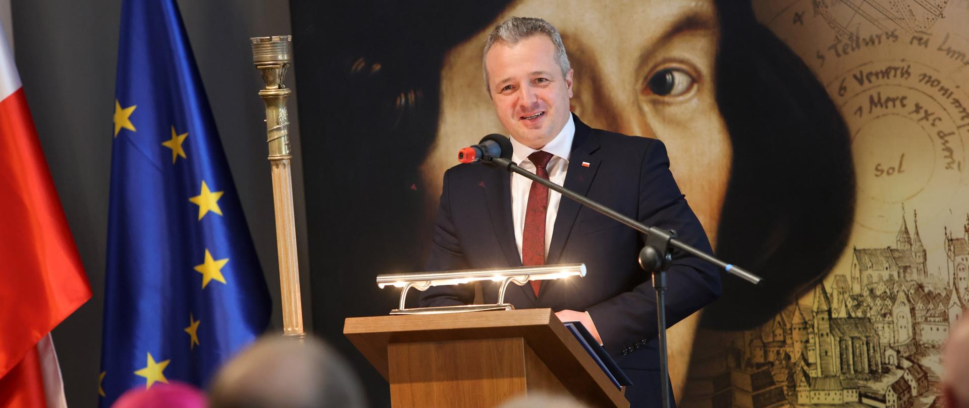 Jeden mężczyzna stojący przy mównicy i wypowiadający się 