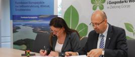 Na zdjęciu sala konferencyjna. Przy stole siedzi od lewej prezes Zakładu Wodociągów i Kanalizacji w Świnoujściu Dorota Janowicz, obok niej Robert Gajda, zastępca prezesa zarządu Narodowego Funduszu Ochrony Środowiska i Gospodarki Wodnej. Podpisują leżące na stole umowy