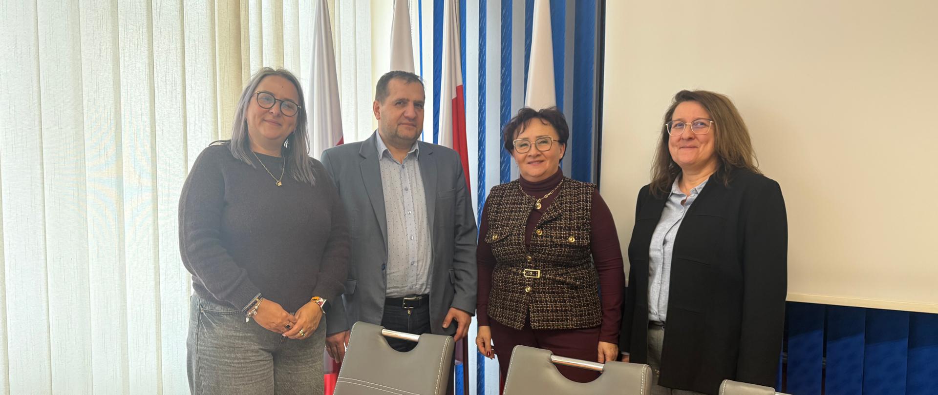 Trzy kobiety i jeden mężczyzna pozujący do zdjęcia