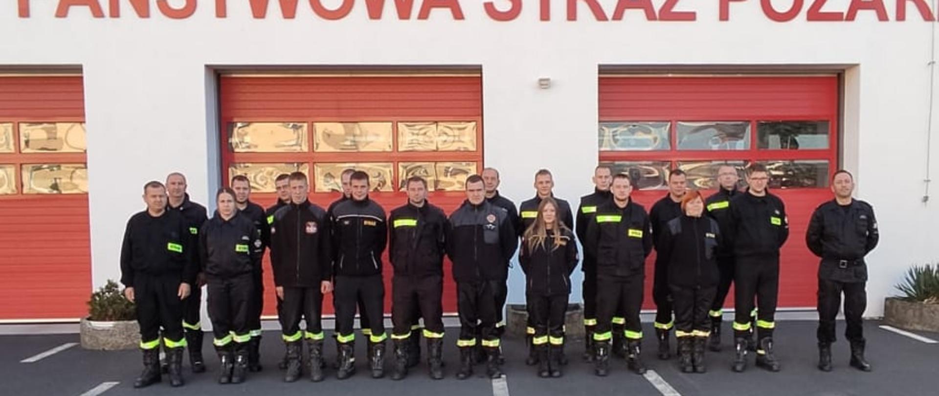 Zdjęcie przedstawia druhny i druhów z OSP z terenu powiatu obornickiego na tle strażnicy KP PSP w Obornikach