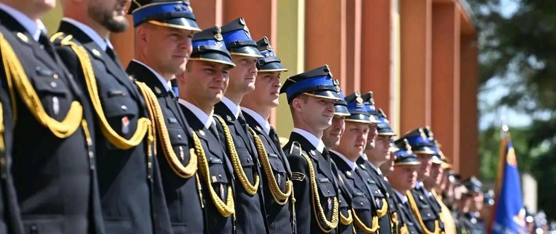 strażacy stojących w szeregu przed budynkiem zdjęciu wykonane z ukosa