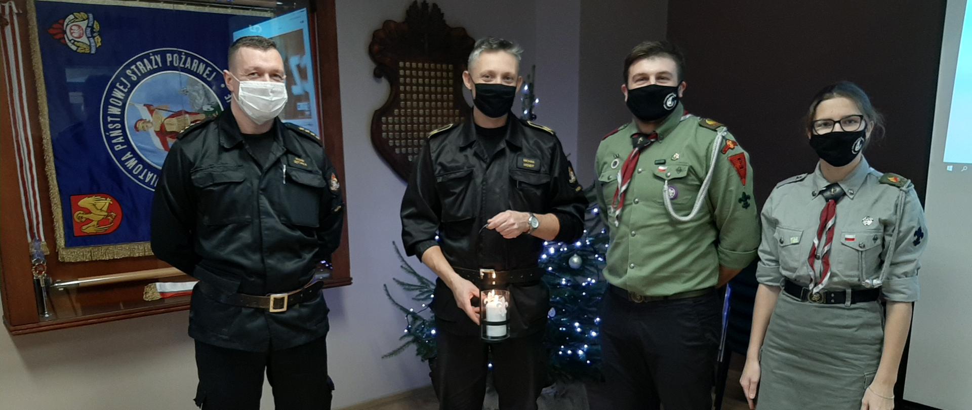 Zdjęcie przedstawia funkcjonariuszy PSP w Kwidzynie przyjmujących Światełko Pokoju od harcerzy ZHP.