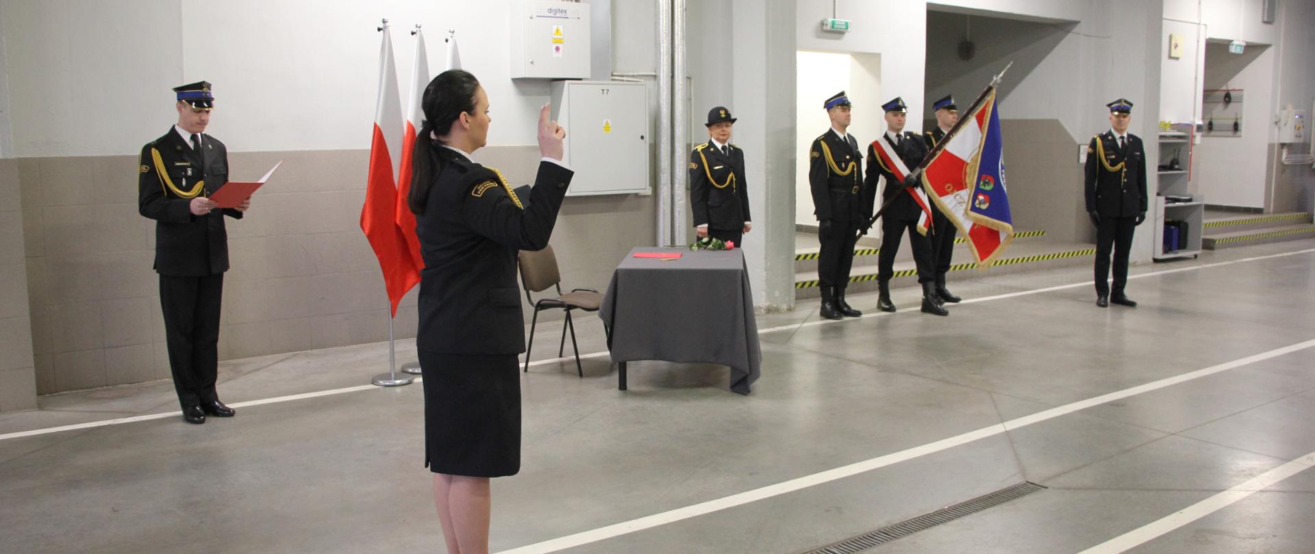 Strażacy w mundurach stoją w pomieszczeniu.